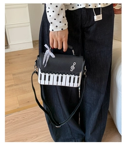 Detail of creative piano keyboard handbag with polka dots and music note charm