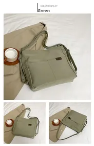 Detail view of green nylon multi-way bag with front pockets and adjustable strap