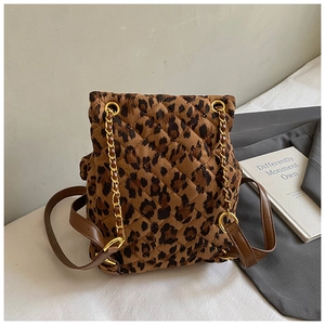 Detail eines gesteppten Rucksacks mit Leopardenmuster, Goldkette und braunen Lederriemen