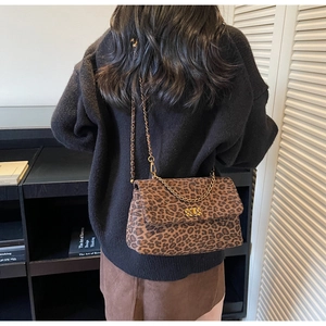 Close-up of leopard print shoulder bag with gold chain strap and rotary metal lock