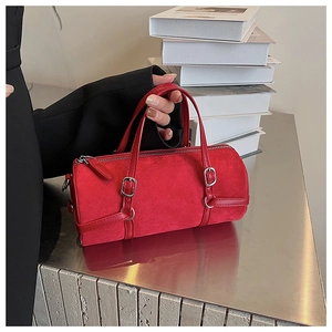 Detailed macro view of the red cylindrical bag showing matte texture and silver buckle