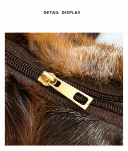 Close-up of premium gold metal zipper and glossy brown fox fur texture on the handbag
