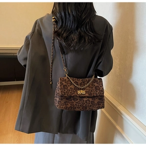Detail of leopard print crossbody bag with gold chain strap and vintage twist lock