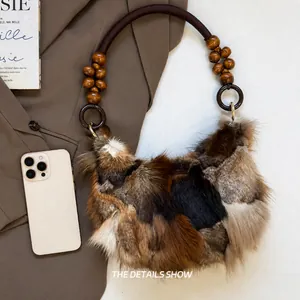 Detail of color-block faux fur handbag with beaded handle and smartphone for scale