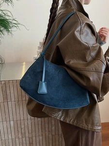 Navy blue suede crescent shoulder bag with slim leather strap and square tag detail