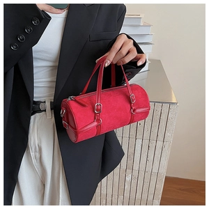 Close-up of vibrant red suede cylinder bag with elegant silver hardware and long handles