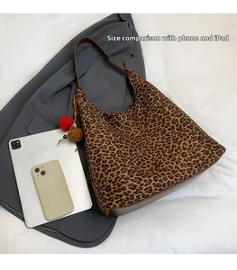 Detailed size comparison of leopard print tote bag with phone and iPad for capacity