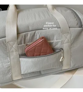 Detail view of the exterior zipper pocket on grey nylon travel bag for convenient storage