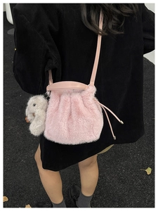 Vue détaillée du sac bourse en fausse fourrure rose avec pendentif lapin gris doux