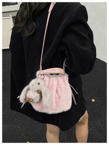 Détail du sac seau rose en fausse fourrure avec cordon et breloque lapin à oreilles