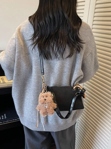 Chic black crossbody bucket bag with gold chain decoration and plush bear charm