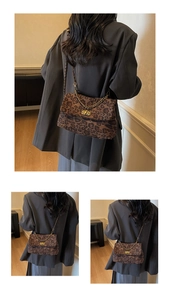 Detail shot of leopard print handbag featuring a gold metal chain and square twist lock