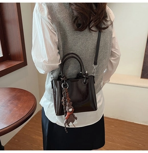 Dettaglio della borsa a secchiello vintage in pelle cerata marrone scuro a tracolla