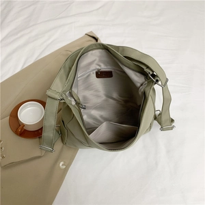 Versatile sage green nylon tote bag showing its spacious interior and zipped inner pocket