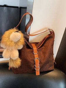 Sac cabas en daim marron foncé avec texture tissée, lanières en cuir et breloque lion