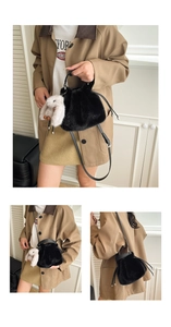 Détail du sac seau noir en fausse fourrure avec un charmant lapin en peluche blanc