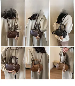 Mini sac Boston rétro avec texture grainée et breloque monstre en peluche sur modèles