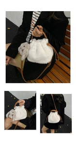 Détail d'un sac seau en peluche blanche avec bandoulière en cuir brun et breloque lapin