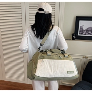 Detailed back view of a large olive green travel duffel bag worn by a model