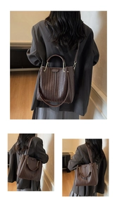 Close-up of dark brown woven leather bucket bag with gold hardware and shoulder strap