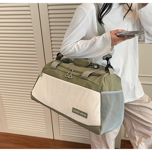 Side view of large canvas travel bag with breathable mesh pocket worn by a model