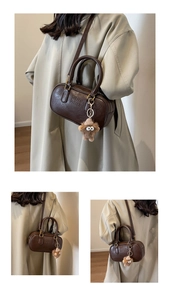 Détail du sac Boston marron vintage avec lettrage ARMI et breloque monstre en peluche