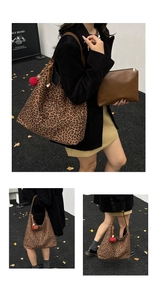 Detail of leopard print tote bag with brown leather straps and a red pompom charm