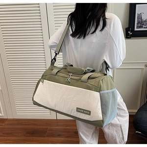 Detail of adjustable thick shoulder strap and side mesh pocket on a large duffel bag