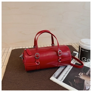 Red cylindrical PU leather handbag with silver hardware and adjustable long strap details