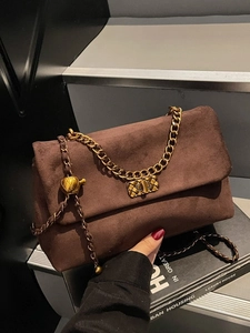 Dark brown suede shoulder bag with gold chain strap and pineapple pendant detail