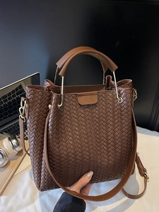 Brown woven tote bag with dual handles and metal chain strap for casual styling