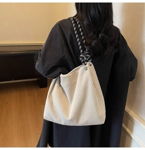 Detail of off-white corduroy tote with stylish black and white braided rope handle
