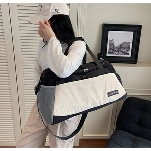 Detail of black and white travel bag showing adjustable strap and breathable side mesh pocket