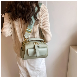 Vue latérale d'un sac bandoulière en cuir vert menthe avec bandoulière large gaufrée