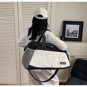 Detailed back view of a large black and white fitness travel bag with adjustable strap