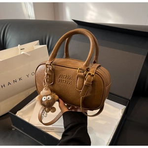 Détail d'un sac Boston marron avec texture en similicuir fin et emballage cadeau de luxe
