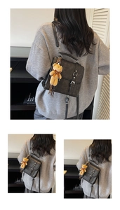 Détail du sac à dos en daim gris foncé avec boucles argentées et pendentif ourson