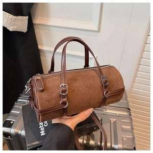 Detailed close-up of brown cylindrical handbag showing leather texture and zipper detail