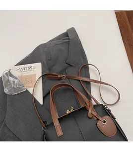 Détail de la bandoulière réglable marron et de la fermeture éclair du sac cabas en noir