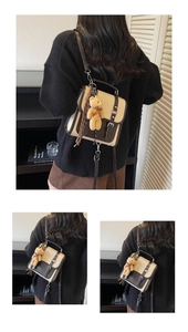 Détail du sac à dos rétro en daim avec rabat contrasté et charmant porte-clés ours