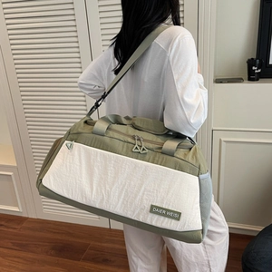 Large capacity green and white travel bag for sports and fitness shown in a home setting