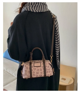 Detailed back view of pink leopard Boston bag with leather handles and gold metal hardware