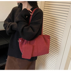 Retro red tote bag with suede texture and matching mini pouch worn by model on shoulder