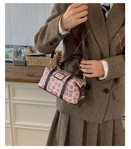 Pink leopard print Boston bag with brown leather handles worn with a vintage brown blazer