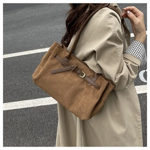 Dettaglio borsa shopper in camoscio marrone con fibbia in metallo e finiture in pelle