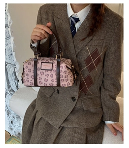 Pink leopard print Boston bag detail featuring leather handles and brand logo patch