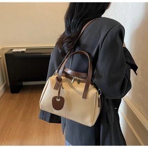 Détail du sac beige bicolore avec lanières brunes et fermeture éclair dorée
