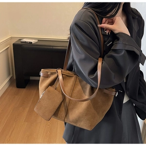 Detail of vintage brown suede tote bag with side straps and matching zipper pouch