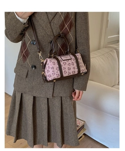 Pink leopard print Boston bag styled with a tailored blazer in a modern interior setting