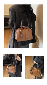 Détails du sac coquille en cuir marron avec garniture dorée et un pendentif coeur chic